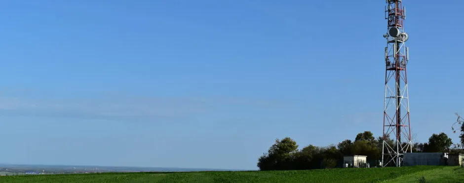 Mobilfunkmast auf einer Freifläche unter weitem Himmel