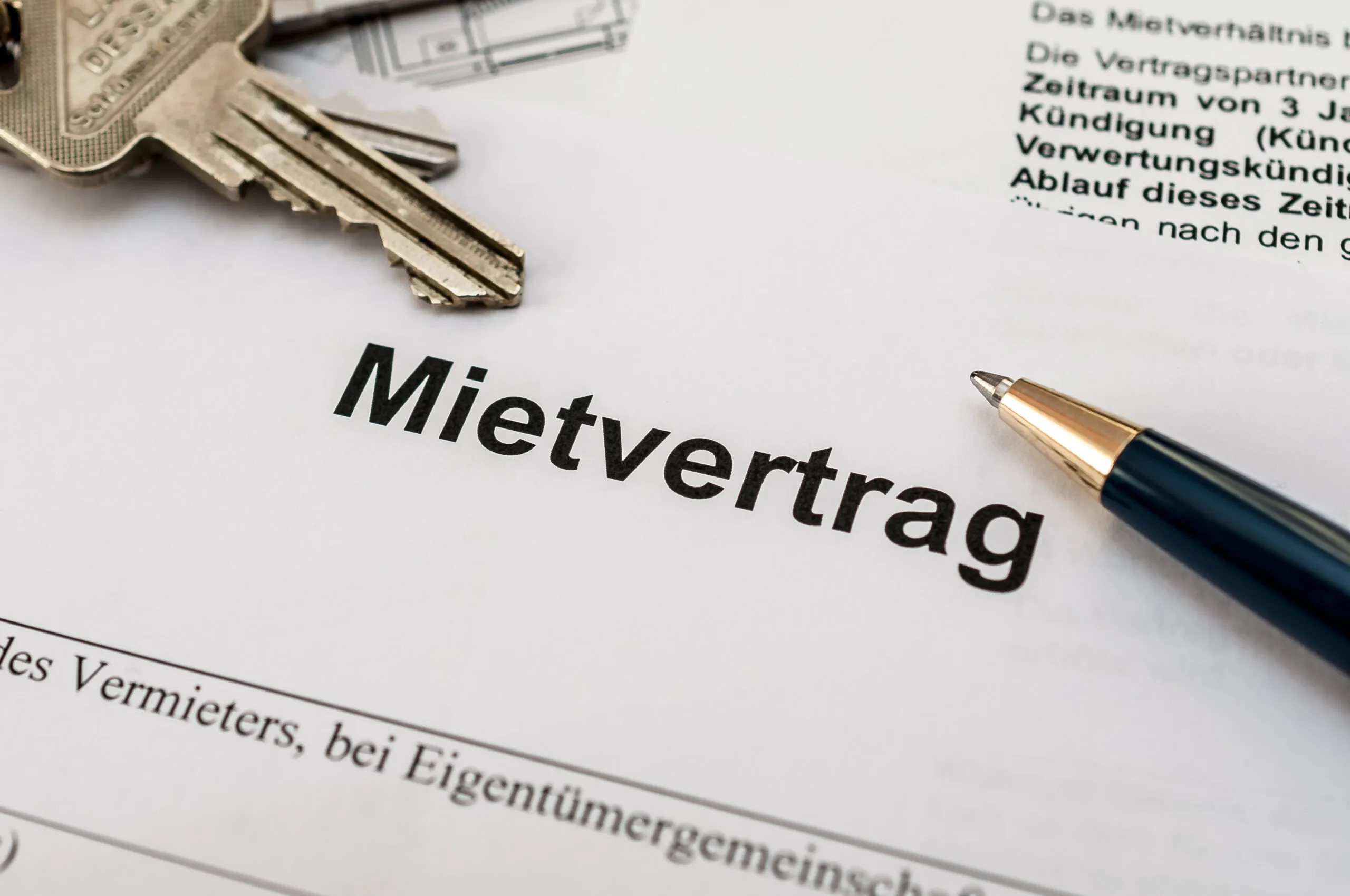 Mietvertrag mit Schlüsselbund und Kugelschreiber auf einem Tisch